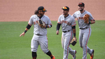 Apr 7, 2021; San Diego, California, USA; San Francisco Giants shortstop Brandon Crawford (L) celebrates with second baseman Donovan Solano (C) and third baseman Evan Longoria (R) after defeating the San Diego Padres at Petco Park. Mandatory Credit: Orlando Ramirez-USA TODAY Sports
