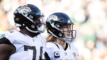 EAST RUTHERFORD, NEW JERSEY - DECEMBER 26: Trevor Lawrence #16 of the Jacksonville Jaguars and Cam Robinson #74 of the Jacksonville Jaguars walk toward the sideline during the the game against the New York Jets at MetLife Stadium on December 26, 2021 in East Rutherford, New Jersey. (Photo by Dustin Satloff/Getty Images)
