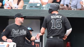 BALTIMORE, MD - AUGUST 25: Trey Mancini #16 of the Baltimore Orioles celebrates scoring with manager Brandon Hyde #18 of the Baltimore Orioles Renato Nunez #39 (not pictured) during a baseball game against the Tampa Bay Rays at Oriole Park at Camden Yards on August 25, 2019 in Baltimore, Maryland. Teams are wearing special color schemed uniforms with players choosing nicknames to display for Players' Weekend. (Photo by Mitchell Layton/Getty Images)