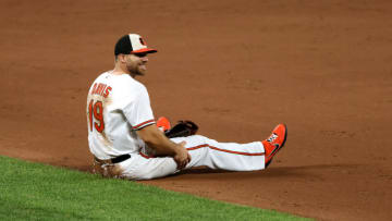 BALTIMORE, MARYLAND - AUGUST 06: First baseman Chris Davis #19 of the Baltimore Orioles sits on the ground after fielding a ball against the Miami Marlins at Oriole Park at Camden Yards on August 06, 2020 in Baltimore, Maryland. (Photo by Rob Carr/Getty Images)