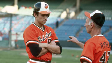 Cal Ripken Jr. #8 of the Baltimore Orioles listens to his father talk Cal Ripken Sr. #47. (Photo by Focus on Sport/Getty Images)