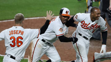 BALTIMORE, MD - JUNE 06: Adam Jones #10 of the Baltimore Orioles celebrates with Caleb Joseph #36 and Jonathan Schoop #6 after scoring the winning run in the tenth inning to give the Orioles a 6-5 win over the Pittsburgh Pirates at Oriole Park at Camden Yards on June 6, 2017 in Baltimore, Maryland. (Photo by Rob Carr/Getty Images)