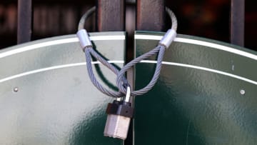 BALTIMORE, MARYLAND - MARCH 26: A lock is wrapped around a closed entrance at Oriole Park at Camden Yards on March 26, 2020 in Baltimore, Maryland. The Baltimore Orioles and New York Yankees Opening Day game scheduled for today, along with the entire MLB season, has been postponed due to the COVID-19 pandemic. (Photo by Rob Carr/Getty Images)