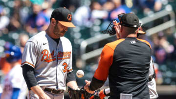 May 12, 2021; New York City, New York, USA; Baltimore Orioles starting pitcher Matt Harvey (32) passes the ball to manager Luis Rojas, right, during the fifth inning against the New York Mets at Citi Field. Mandatory Credit: Vincent Carchietta-USA TODAY Sports