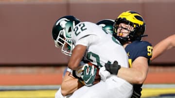 Oct 31, 2020; Ann Arbor, Michigan, USA; Michigan State Spartans running back Jordon Simmons (22) is tackled by Michigan Wolverines defensive lineman Aidan Hutchinson (97) in the first half at Michigan Stadium. Mandatory Credit: Rick Osentoski-USA TODAY Sports