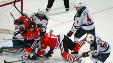Mar 20, 2016; Chicago, IL, USA; Chicago Blackhawks center Andrew Shaw (65) and Minnesota Wild left wing Erik Haula (56) scramble in front of goalie Devan Dubnyk (40) during the third period at the United Center. Minnesota won 3-2 in a shoot out. Mandatory Credit: Dennis Wierzbicki-USA TODAY Sports