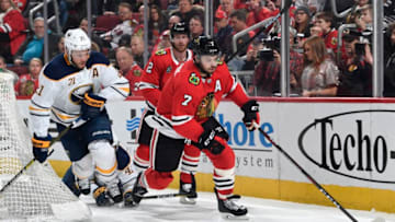 CHICAGO, IL - MARCH 07: Brent Seabrook #7 of the Chicago Blackhawks grabs the puck ahead of Kyle Okposo #21 of the Buffalo Sabres in the second period at the United Center on March 7, 2019 in Chicago, Illinois. (Photo by Bill Smith/NHLI via Getty Images)