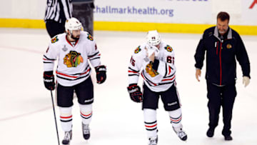 BOSTON, MA - JUNE 24: Andrew Shaw #65 of the Chicago Blackhawks wipes off his face on the ice after being hit in the face with a puck by the Boston Bruins in Game Six of the 2013 NHL Stanley Cup Final at TD Garden on June 24, 2013 in Boston, Massachusetts. (Photo by Jim Rogash/Getty Images)