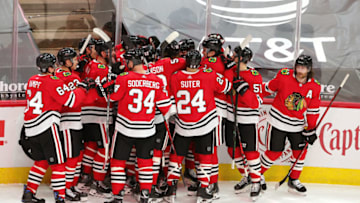 CHICAGO, ILLINOIS - FEBRUARY 13: Alex DeBrincat #12 of the Chicago Blackhawks celebrates with teammates after scoring the game winning goal in overtime against the Columbus Blue Jackets at the United Center on February 13, 2021 in Chicago, Illinois. (Photo by Stacy Revere/Getty Images)