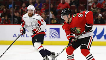 CHICAGO, ILLINOIS - SEPTEMBER 25: Adam Boqvist #27 of the Chicago Blackhawks advances the puck against Liam O'Brien #87 of the Washington Capitals during a preseason game at the United Center on September 25, 2019 in Chicago, Illinois. The Capitals defeated the Blackhawks 6-0. (Photo by Jonathan Daniel/Getty Images)
