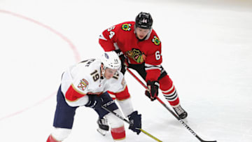 CHICAGO, ILLINOIS - MARCH 23: Mason Marchment #19 of the Florida Panthers moves against David Kampf #64 of the Chicago Blackhawks at the United Center on March 23, 2021 in Chicago, Illinois. The Blackhawks defeated the Panthers 3-2. (Photo by Jonathan Daniel/Getty Images)