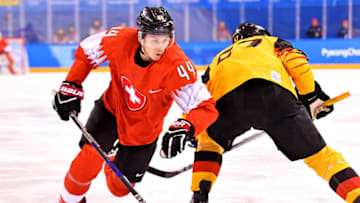 Feb 20, 2018; Gangneung, South Korea; Switzerland forward Pius Suter (44) and Germany forward Patrick Reimer (37) during men's ice hockey qualifications for quarterfinals in the Pyeongchang 2018 Olympic Winter Games at Gangneung Hockey Centre. Mandatory Credit: Robert Hanashiro-USA TODAY Sports