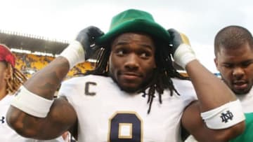 Nov 7, 2015; Pittsburgh, PA, USA; Notre Dame Fighting Irish linebacker Jaylon Smith (9) puts on the hat of the Fighting Irish leprechaun mascot after defeating the Pittsburgh Panthers at Heinz Field. Notre Dame won 42-30. Mandatory Credit: Charles LeClaire-USA TODAY Sports