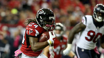 Oct 4, 2015; Atlanta, GA, USA; Atlanta Falcons running back Devonta Freeman (24) runs for a touchdown past Houston Texans linebacker Jadeveon Clowney (90) in the first quarter of their game at the Georgia Dome. Mandatory Credit: Jason Getz-USA TODAY Sports
