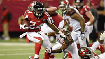 Nov 1, 2015; Atlanta, GA, USA; Atlanta Falcons running back Devonta Freeman (24) breaks a tackle by Tampa Bay Buccaneers cornerback Alterraun Verner (21) during the first half at the Georgia Dome. Mandatory Credit: Dale Zanine-USA TODAY Sports