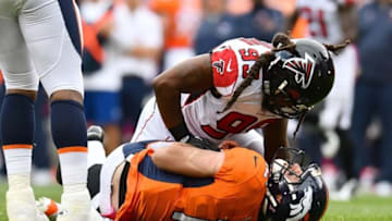 Oct 9, 2016; Denver, CO, USA; Denver Broncos quarterback Paxton Lynch (12) is tackled to the turf by Atlanta Falcons defensive end Adrian Clayborn (99) in the second half at Sports Authority Field at Mile High. The Falcons defeated the Broncos 23-16. Mandatory Credit: Ron Chenoy-USA TODAY Sports