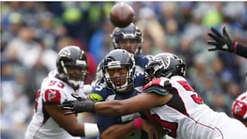 Oct 16, 2016; Seattle, WA, USA; Seattle Seahawks quarterback Russell Wilson (3) hit by Atlanta Falcons defensive end Derrick Shelby (90) after throwing a pass during the fourth quarter at CenturyLink Field. Seattle defeated Atlanta, 26-24. Mandatory Credit: Joe Nicholson-USA TODAY Sports