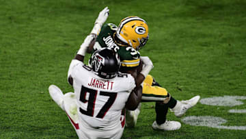 GREEN BAY, WISCONSIN - OCTOBER 05: Aaron Jones #33 of the Green Bay Packers is brought down by Grady Jarrett #97 of the Atlanta Falcons during a game at Lambeau Field on October 05, 2020 in Green Bay, Wisconsin. The Packers defeated the Falcons 30-16. (Photo by Stacy Revere/Getty Images)