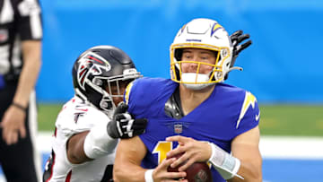 INGLEWOOD, CALIFORNIA - DECEMBER 13: Justin Herbert #10 of the Los Angeles Chargers is pursued by Dante Fowler Jr. #56 of the Atlanta Falcons during the third quarter at SoFi Stadium on December 13, 2020 in Inglewood, California. (Photo by Sean M. Haffey/Getty Images)