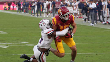 LOS ANGELES, CALIFORNIA - OCTOBER 30: Wide receiver Drake London #15 of the USC Trojans catches the ball against cornerback Christian Roland-Wallace (4) of the Arizona Wildcats during a college football game between the Arizona Wildcats and the USC Trojans at Los Angeles Memorial Coliseum on October 30, 2021 in Los Angeles, California. (Photo by Leon Bennett/Getty Images)