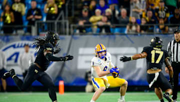 CHARLOTTE, NORTH CAROLINA - DECEMBER 04: Kenny Pickett #8 of the Pittsburgh Panthers runs against Luiji Vilain #2 of the Wake Forest Demon Deacons and Traveon Redd #17 of the Wake Forest Demon Deacons during the first half of the ACC Championship game at Bank of America Stadium on December 04, 2021 in Charlotte, North Carolina. (Photo by Logan Whitton/Getty Images)