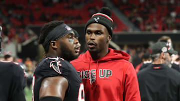 Nov 28, 2019; Atlanta, GA, USA; Injured Atlanta Falcons wide receiver Julio Jones, center, talks with defensive tackle Grady Jarrett, left, in the second half of their game against the New Orleans Saints at Mercedes-Benz Stadium. Mandatory Credit: Jason Getz-USA TODAY Sports