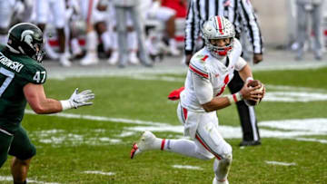 Ohio State's Justin Fields runs the ball as Jeff Pietrowski closes in during the third quarter on Saturday, Dec. 5, 2020, at Spartan Stadium in East Lansing.201205 Msu Osu 158a