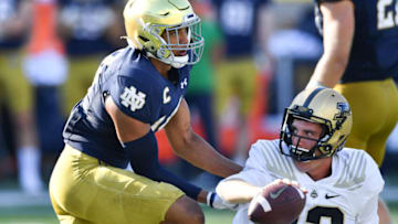 Sep 18, 2021; South Bend, Indiana, USA; Purdue Boilermakers quarterback Jack Plummer (13) is helped up after being tackled by Notre Dame Fighting Irish safety Kyle Hamilton (14) in the third quarter at Notre Dame Stadium. Mandatory Credit: Matt Cashore-USA TODAY Sports