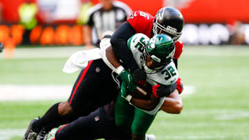 Oct 10, 2021; London, England, United Kingdom; New York Jets running back Michael Carter (32) is tackled by Atlanta Falcons defensive end Dante Fowler Jr. (6) in the first half at Tottenham Hotspur Stadium. Mandatory Credit: Nathan Ray Seebeck-USA TODAY Sports