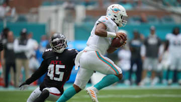 Oct 24, 2021; Miami Gardens, Florida, USA; Miami Dolphins quarterback Tua Tagovailoa (1) scrambles past Atlanta Falcons linebacker Deion Jones (45) during the first half at Hard Rock Stadium. Mandatory Credit: Jasen Vinlove-USA TODAY Sports