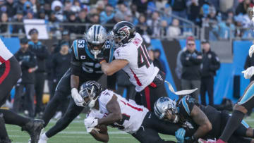 Dec 12, 2021; Charlotte, North Carolina, USA; Atlanta Falcons wide receiver Russell Gage (14) is tackled as Carolina Panthers defensive end Brian Burns (53) grabs the facemask during the second half at Bank of America Stadium. Mandatory Credit: William Howard-USA TODAY Sports