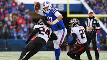 Jan 2, 2022; Orchard Park, New York, USA; Buffalo Bills quarterback Josh Allen (17) splits Atlanta Falcons cornerback A.J. Terrell (24) and safety Duron Harmon (21) on a run during the first half at Highmark Stadium. Mandatory Credit: Rich Barnes-USA TODAY Sports
