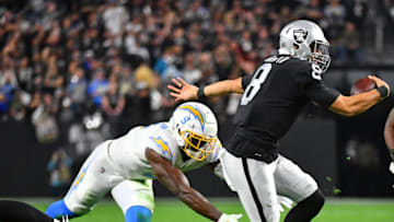 Jan 9, 2022; Paradise, Nevada, USA; Las Vegas Raiders quarterback Marcus Mariota (8) evades the tackle attempt of Los Angeles Chargers middle linebacker Kenneth Murray (9) at Allegiant Stadium. Mandatory Credit: Stephen R. Sylvanie-USA TODAY Sports