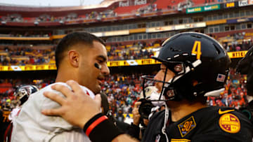 Nov 27, 2022; Landover, Maryland, USA; Washington Commanders quarterback Taylor Heinicke (4) hugs Atlanta Falcons quarterback Marcus Mariota (1) after their game at FedExField. Mandatory Credit: Geoff Burke-USA TODAY Sports