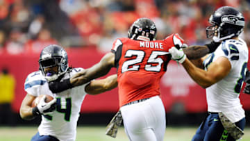 Nov 10, 2013; Atlanta, GA, USA; Seattle Seahawks running back Marshawn Lynch (24) fights off Atlanta Falcons safety William Moore (25) during the second quarter at the Georgia Dome. Mandatory Credit: Dale Zanine-USA TODAY Sports
