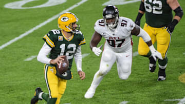 Oct 5, 2020; Green Bay, Wisconsin, USA; Green Bay Packers quarterback Aaron Rodgers (12) scrambles away from Atlanta Falcons defensive tackle Grady Jarrett (97) in the second quarter at Lambeau Field. Mandatory Credit: Benny Sieu-USA TODAY Sports