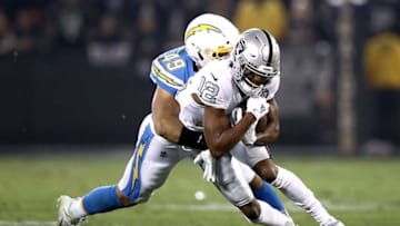 OAKLAND, CALIFORNIA - NOVEMBER 07: Wide receiver Zay Jones #12 of the Oakland Raiders is tackled by the linebacker Drue Tranquill #49 of the Los Angeles Chargers during the game at RingCentral Coliseum on November 07, 2019 in Oakland, California. (Photo by Ezra Shaw/Getty Images)
