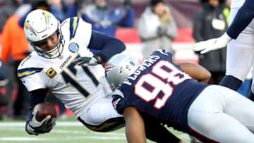 FOXBOROUGH, MASSACHUSETTS - JANUARY 13: Philip Rivers #17 of the Los Angeles Chargers is tackled by Trey Flowers #98 of the New England Patriots during the third quarter in the AFC Divisional Playoff Game at Gillette Stadium on January 13, 2019 in Foxborough, Massachusetts. (Photo by Al Bello/Getty Images)