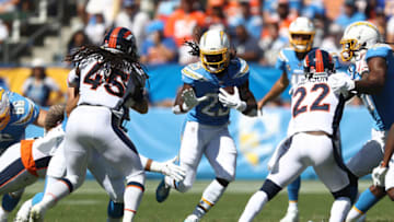 CARSON, CALIFORNIA - OCTOBER 06: Melvin Gordon #25 of the Los Angeles Chargers runs the ball as Kareem Jackson #22 and Alexander Johnson #45 of the Denver Broncos defend during the first half of a game at Dignity Health Sports Park on October 06, 2019 in Carson, California. (Photo by Sean M. Haffey/Getty Images)