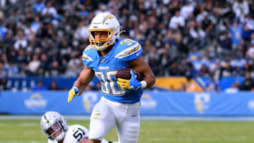 CARSON, CALIFORNIA - DECEMBER 22: Austin Ekeler #30 of the Los Angeles Chargers runs after breaking a tackle from Will Compton #51 of the Oakland Raiders during the second quarter at Dignity Health Sports Park on December 22, 2019 in Carson, California. (Photo by Harry How/Getty Images)