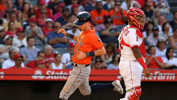 ANAHEIM, CA - JULY 21: Martin Maldonado #12 of the Los Angeles Angels of Anaheim looks on as Kyle Tucker #3 of the Houston Astros scores on a sacrifice fly by Yuli Gurriel #10 of the Houston Astros in the third inning of the game at Angel Stadium on July 21, 2018 in Anaheim, California. (Photo by Jayne Kamin-Oncea/Getty Images)