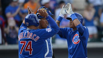 Mar 7, 2016; Mesa, AZ, USA; Chicago Cubs second baseman Addison Russell (27) slaps hands with first baseman Dan Vogelbach (74) in front of Kansas City Royals catcher Salvador Perez (13) after hitting a home run in the fifth inning at Sloan Park. Mandatory Credit: Joe Camporeale-USA TODAY Sports