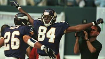IRVING, : Minnesota Vikings receiver Randy Moss (C) celebrates his 51 yard touchdown reception on the fourth play of the game versus the Dallas Cowboys at Texas Stadium in Irving, TX, 26 November. At left is teammate Robert Smith. AFP PHOTO/PAUL BUCK (Photo credit should read PAUL BUCK/AFP via Getty Images)