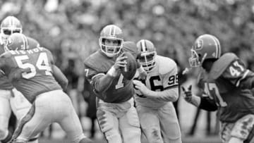 CLEVELAND, OH - JANUARY 11: (EDITORS NOTE: Image has been shot in black and white. Color version not available.) Quarterback John Elway #7 of the Denver Broncos runs with the football as he is pursued by defensive lineman Reggie Camp #96 of the Cleveland Browns as offensive lineman Keith Bishop #54 blocks and running back Gerald Willhite #47 follows the play during the 1986 season AFC Championship Game at Cleveland Municipal Stadium on January 11, 1987 in Cleveland, Ohio. The Broncos defeated the Browns 23-20. (Photo by George Gojkovich/Getty Images)