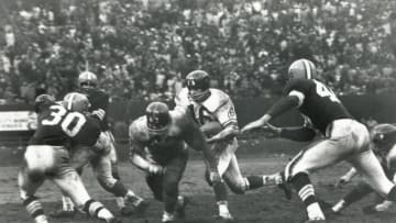 CLEVELAND - NOVEMBER 6: Frank Gifford #16 of the New York Giants follows the block of Darrell Dess #62 against Bernie Parrish #30 and Don Fleming #46 of the Cleveland Browns during the game at Cleveland Stadium on November 6, 1960 in Cleveland, Ohio. (Photo by Robert Riger/Getty Images)