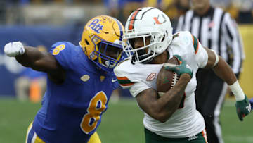 Oct 30, 2021; Pittsburgh, Pennsylvania, USA; Miami Hurricanes running back Jaylan Knighton (4) runs against Pittsburgh Panthers defensive lineman Calijah Kancey (8) after a catch during the fourth quarter at Heinz Field. Miami won 38-34. Mandatory Credit: Charles LeClaire-USA TODAY Sports