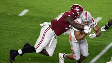 Jan 11, 2021; Miami Gardens, FL, USA; Ohio State Buckeyes running back Master Teague III (33) is tackled by Alabama Crimson Tide defensive lineman Christian Barmore (58) in the second quarter in the 2021 College Football Playoff National Championship Game at Hard Rock Stadium. Mandatory Credit: Douglas DeFelice-USA TODAY Sports