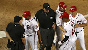 WASHINGTON, DC - AUGUST 08: Manager Dave Martinez #4 of the Washington Nationals and umpire Greg Gibson #53 argue as Juan Soto #22 of the Washington Nationals is pushed away by his coaching staff against the Atlanta Braves during the sixth inning at Nationals Park on August 8, 2018 in Washington, DC. (Photo by Patrick Smith/Getty Images)