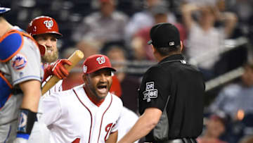 WASHINGTON, DC - SEPTEMBER 20: Manager Dave Martinez #4 of the Washington Nationals holds back Bryce Harper #34 from umpire D.J. Rayburn after getting thrown out in the 12th inning during a baseball game against the New York Mets at Nationals Park on September 20, 2018 in Washington, DC. (Photo by Mitchell Layton/Getty Images)