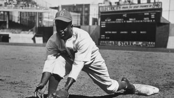 American baseball player Jackie Robinson (1919 - 1972) grounds a ball at first place while warming up for an exhibition game against the New York Yankees, Ebbets Field, NYC, 1950s. (Photo by Hulton|Archive/Getty Images)